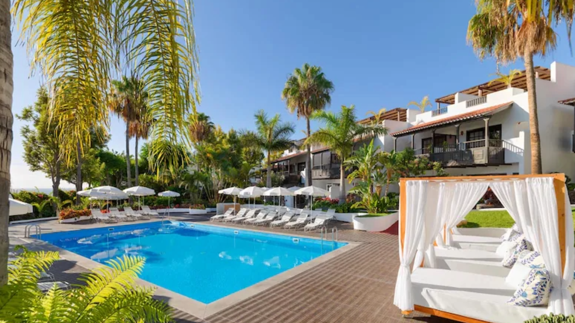 piscine avec des chaises longues et lits au bord de la piscine à l'hotel jardin tecina à playa santiago à la gomera